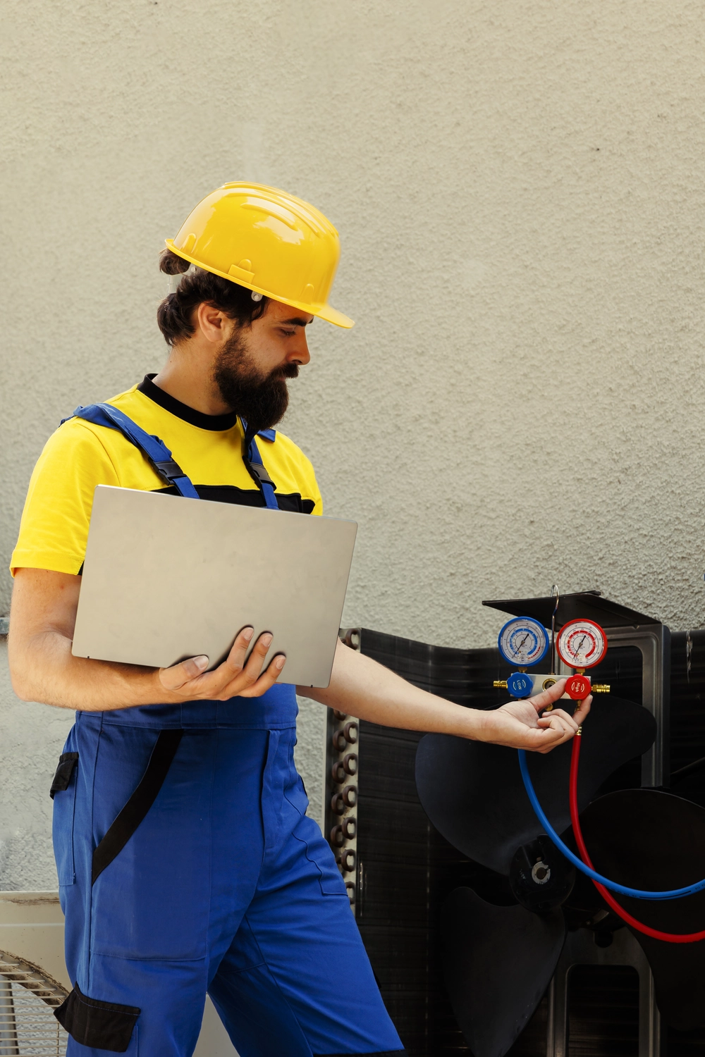 Elektro Wollmer GmbH - Innovative Klimatechnik - Ein effizienter Klimatechniker prüft in angenehmer Innenraumatmosphäre eine Klimaanlage in einem Haus. Er hält ein Klemmbrett in der Hand. Seine Technik wirkt professionell und kompetent.